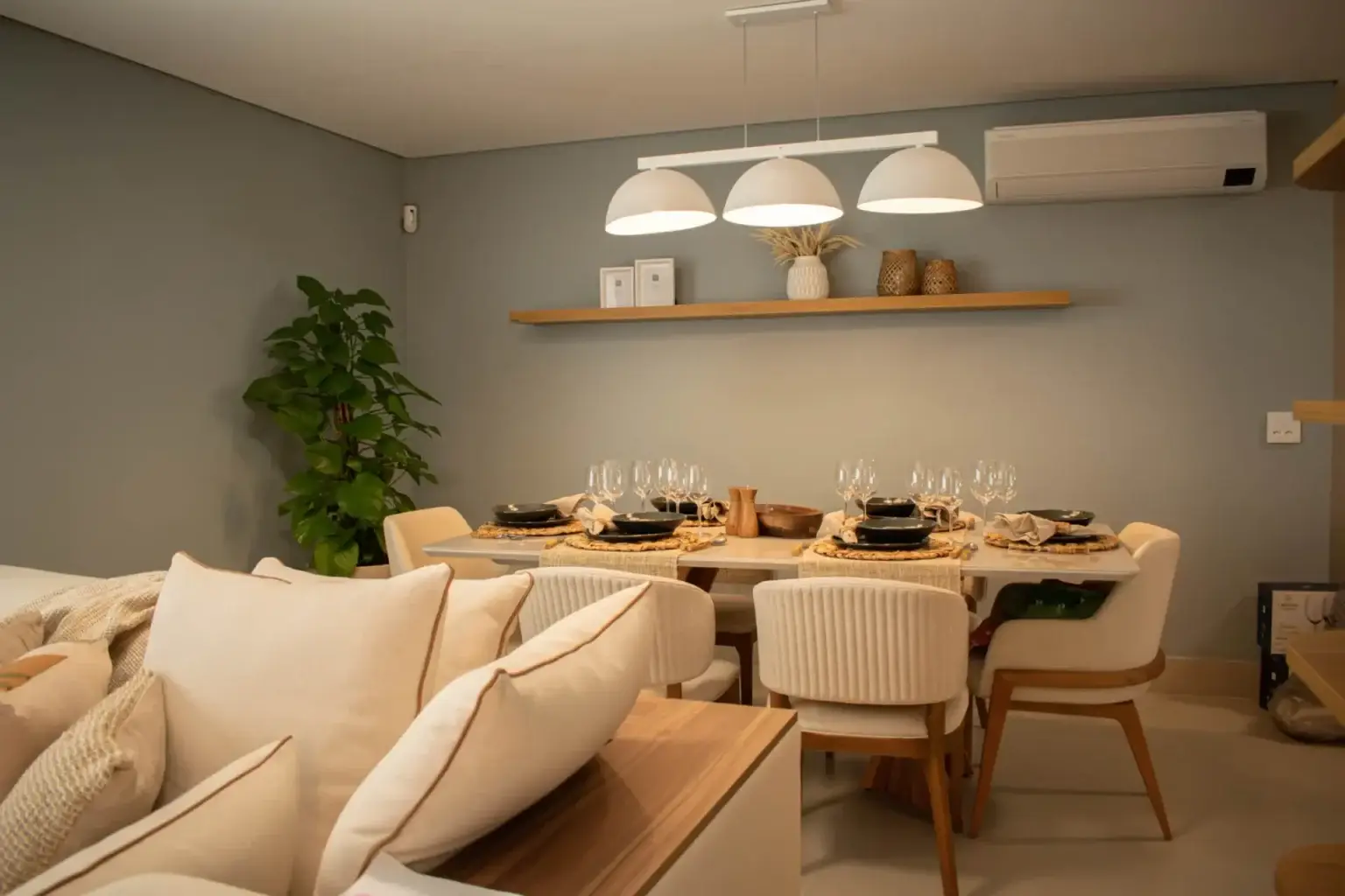 Sala de jantar planejada com mesa elegante e cadeiras estofadas em apartamento reformado